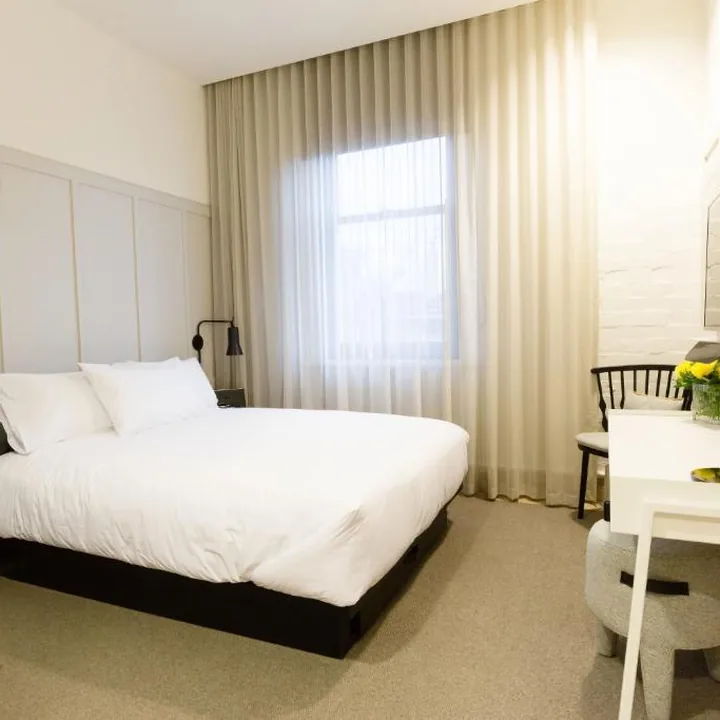 King room with panelled walls and crisp white linen